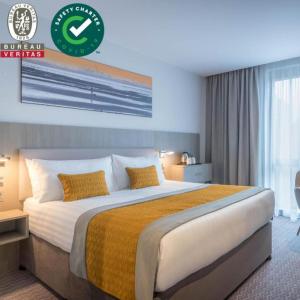 um quarto com uma cama grande num quarto em Maldron Hotel Smithfield em Dublin