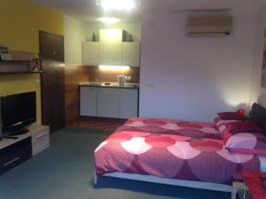 a bedroom with a pink bed and a kitchen at Rostohar Guest House in Bled