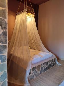 Bett mit Moskitonetz in einem Zimmer in der Unterkunft Maria's Paradise in Vónitsa