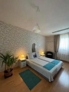 a bedroom with a large bed with two lights on at Tápé in Szeged
