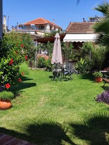 a yard with a table with an umbrella and chairs at Maria's Paradise in Vonitsa