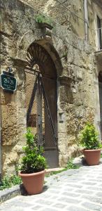 an entrance to a stone building with two potted plants at Antica Dimora Historic Building in Enna