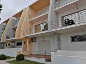 ein Mehrfamilienhaus mit Balkonen und einer Garage in der Unterkunft Townhouse Senhora da Rocha - Alporchinhos in Armação de Pêra