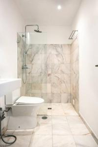 ein weißes Badezimmer mit Dusche und Toilette in der Unterkunft Townhouse Senhora da Rocha - Alporchinhos in Armação de Pêra