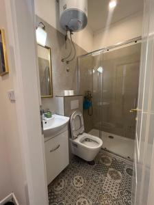 y baño con aseo, lavabo y ducha. en Aria Apartments Sarajevo, en Sarajevo