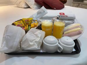 uma bandeja com duas chávenas e duas bebidas numa mesa em Expo Hotel em São Paulo