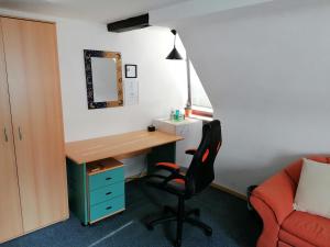 een kamer met een bureau en een stoel bij Großes Gästezimmer mit Kühlschrank in Marbach am Neckar