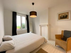 a bedroom with a bed and a window and a chair at Kleine Dijk in Diksmuide