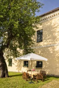 a table with an umbrella in front of a building at Landhaus im Waldviertel in Zwettl Stadt