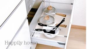 a kitchen with two pots and pans in a refrigerator at happily house 
