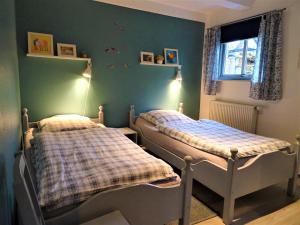 SilberstedtにあるFerienwohnung Marxの緑の壁のベッドルームにツインベッド2台が備わります。
