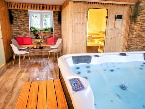 a large tub in a room with a table and chairs at Le Manoir de la Rulette 20P well-ness BBQ Jardin terrasse ping pong salle de jeux in Tintigny