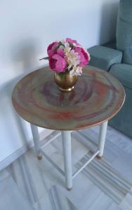 Una pequeña mesa con un jarrón de flores. en Golddem Yolamar Benalmadena, en Benalmádena