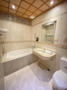 a bathroom with a sink and a tub and a toilet at I Live Motel in Kaohsiung