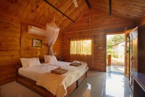 una camera con un letto in una cabina di legno di Zen Cottages ad Agonda
