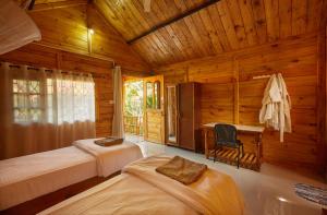 una camera con 2 letti e una scrivania in una cabina di Zen Cottages ad Agonda