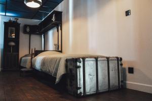 a bedroom with a bed with a trunk next to it at La Chapelle du Carmel - Centre ville - 340 M2 - SPA - Cinéma - Parking - in Reims