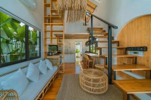 a living room with a couch and a spiral staircase at Villa Tiny - Romantic A-Shape 1BR Villa Close to Nyanyi Beach in Tanah Lot