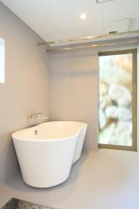 a white bath tub in a bathroom with a window at Carpe Diem Kamaida in Ochi