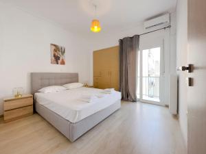 a white bedroom with a large bed and a window at Aristotelous Spacious 109sqm apt in Athens in Athens