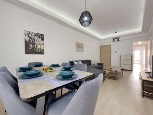 a living room with a table and chairs and a couch at Aristotelous Spacious 109sqm apt in Athens in Athens