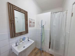 a bathroom with a shower and a sink and a mirror at Palmview House in Hermanus