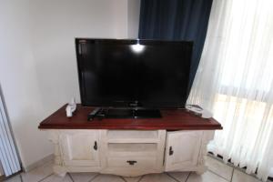 uma televisão de ecrã plano em cima de um armário de madeira em See Uitsig 7 em Margate