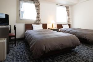 Postel nebo postele na pokoji v ubytování Kurashiki Station Hotel