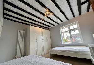 a bedroom with a white bed and a window at The Windmill in Busheyheath