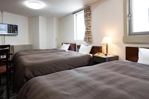 Postel nebo postele na pokoji v ubytování Kurashiki Station Hotel