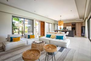 a living room with two white couches and a kitchen at Villa Luxe Anahita Ile Maurice in Beau Champ