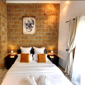 Un dormitorio con una gran cama blanca con una pared de ladrillo. en Maison Prestige Saint Tropez by Roberto Geissini, en Grimaud 42 fotos más