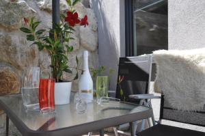 Ferienwohnung Bärbel في ساوتينس: طاولة زجاجية مع زجاجة من النبيذ ونبتة