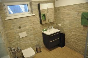 La salle de bains est pourvue d'un lavabo, de toilettes et d'un miroir. dans l'établissement Ferienwohnung Bärbel, à Sautens