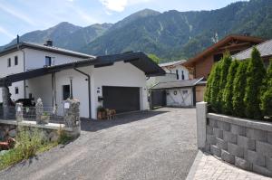 a driveway of a house with mountains in the background at Ferienwohnung Bärbel in Sautens