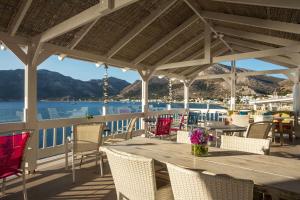 a table and chairs on a deck with a view of the water at ILIDI Rock in Livadia