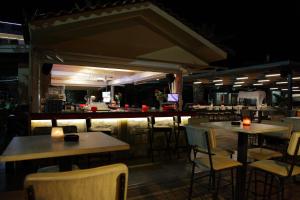 a restaurant with tables and chairs and a bar at Evvoiki Akti Hotel in Politika