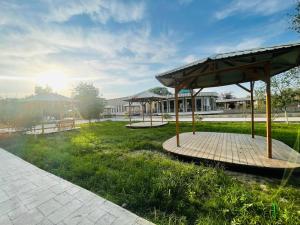 a park with two benches and a pavilion at Shokhjakhon Parvoz in Khiva