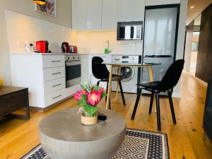 een keuken en een woonkamer met een tafel en stoelen bij Urban Elephant. The Docklands in Kaapstad