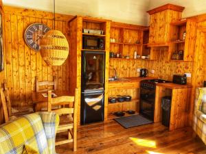a kitchen with a refrigerator and a clock on the wall at Dulrush Self-Catering Lodges in Belleek