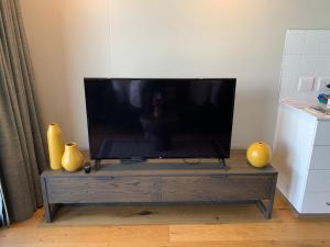 a flat screen tv sitting on top of a wooden entertainment center at Urban Elephant. The Docklands in Cape Town