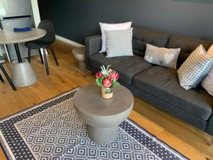 a living room with a couch and a table with flowers at Urban Elephant. The Docklands in Cape Town
