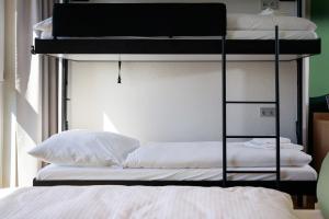 a bunk bed with white sheets and pillows on it at LyvInn Hotel Frankfurt in Frankfurt/Main +62 photos
