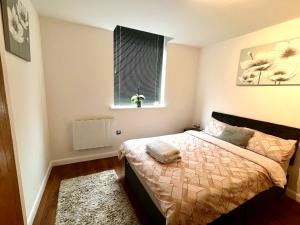 a bedroom with a bed and a window at Captivating 2-Bed Apartment in Bedford in Bedford