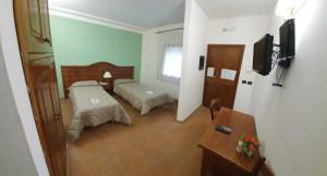 a hotel room with two beds and a television at Hotel Tenuta dell'Argento Resort in Civitavecchia