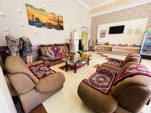 una gran sala de estar con sofás y TV. en Shokhjakhon Parvoz, en Khiva