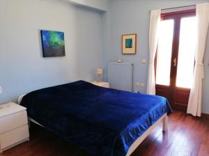 a bedroom with a blue bed and a window at Litani House in Raches