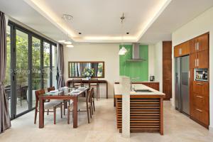 een keuken en eetkamer met een tafel en stoelen bij Tran Beach Front Luxury Villa in Da Nang