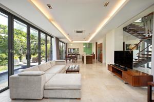 a living room with a couch and a tv at Tran Beach Front Luxury Villa in Da Nang