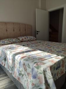 1 cama con edredón de flores en un dormitorio en çamlıbel şelale villaları, en Alanya